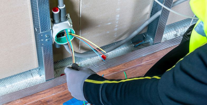 Installer pulling cable through flexible conduit